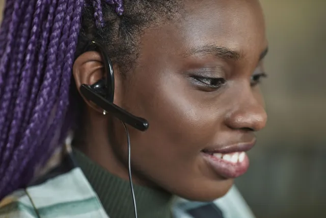 Smiling support specialist in a headset at her desk