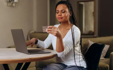Woman shopping online with a bank card and a laptop