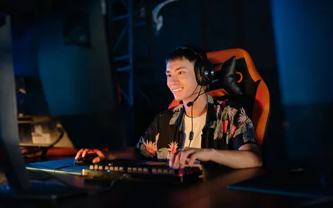 Smiling gamer in a headset playing at his computer