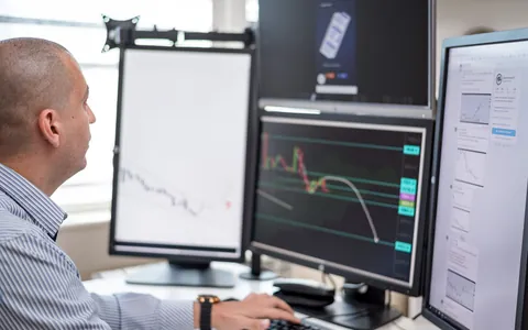 Trader watching charts on several monitors